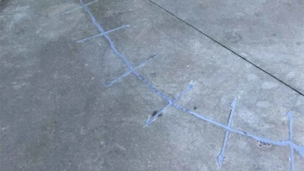 A wide crack running diagonally across a poured concrete slab