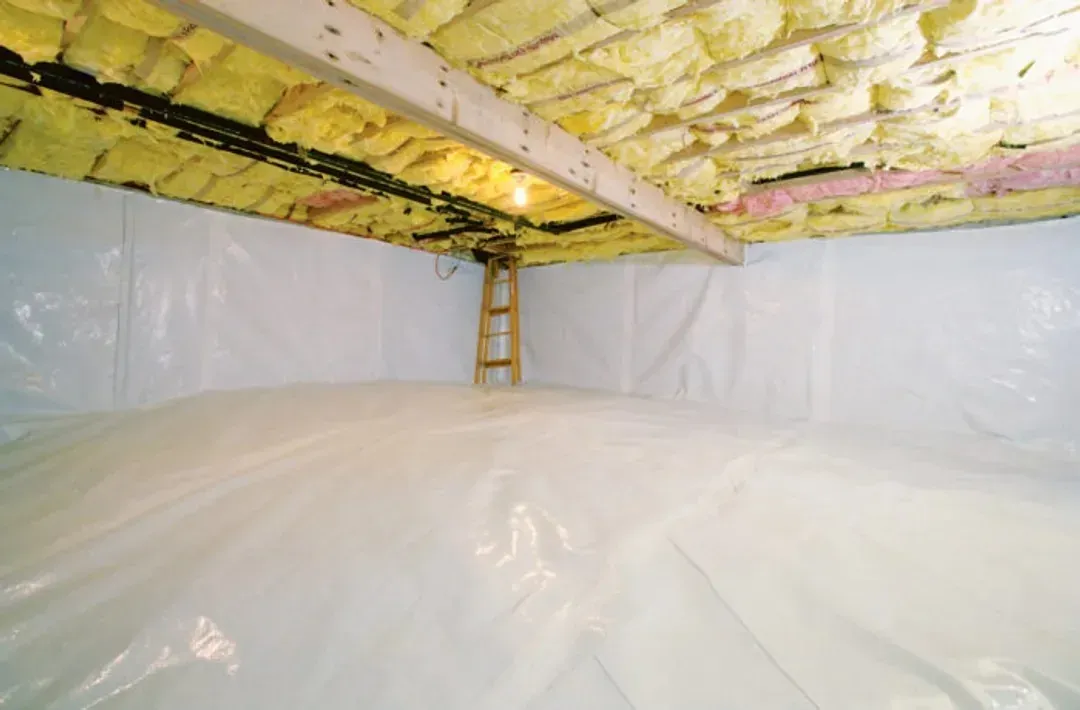 A crawl space with spray-foam insulated walls and a vapour barrier sealed across the ground